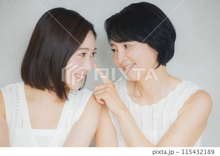 頬に手を当てる親子 115432189