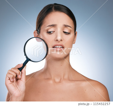Woman, surprise and magnify for face skincare or beauty, botox and anti aging on blue background. Cosmetology, retinol or spot control for treatment, pamper or dermatology for female person in studio 115432257