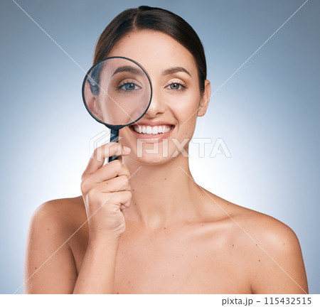 Woman, portrait and magnify glass for skincare or beauty, botox or anti aging on blue background. Cosmetology, retinol or spot control for treatment, pamper or dermatology for female person in studio 115432515
