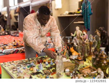 South African man selects antiques at a flea market South African man selects antiques at a flea market 115432691