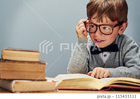 Boy, books and smile in studio with space for mockup, glasses and thinking for learning by blue background. Child, textbook and education for future, study or scholarship for development at academy Boy, books and smile in studio with space for mockup, glasses and thinking for learning by blue background. Child, textbook and education for future, study or scholarship for development at academy 115433111