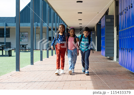 Biracial boy and girls walk together in a school corridor 115433379