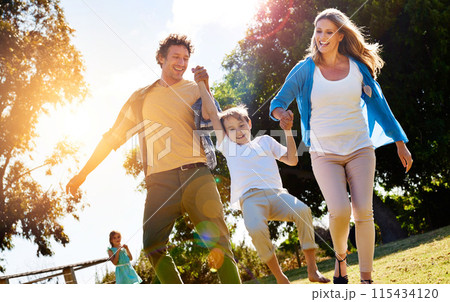 Smile, family and child with holding hands in park for sunshine adventure, vacation and holiday. Woman, man and son with love at countryside for bonding, development and support on fathers day 115434120