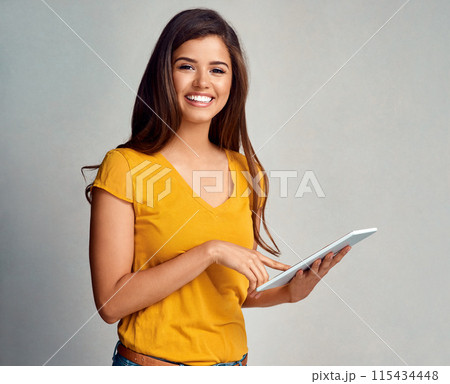 Woman, happy and portrait with tablet in studio background for social media, networking and communication. Female person, smile and satisfied with good news, streaming platform and entertainment 115434448