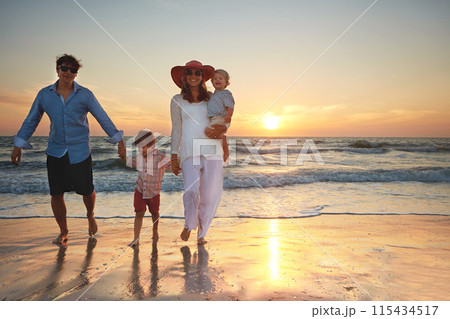 Family, parents and children holding hands on beach trip for holiday fun, vacation and adventure with love. Couple, man and woman and kids on seashore walking with sunset for summer break and support 115434517