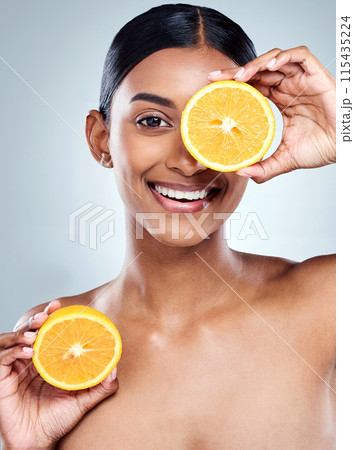 Indian woman, orange and smile for organic beauty, hand and fruit on white background. Citrus, food or vitamin c for hydrated skin or body care, studio and vegan skincare with happy female person 115435224