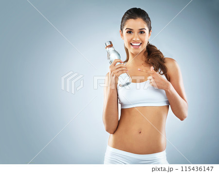 Happy woman, portrait or pointing to water in studio marketing exercise, workout or fitness training. Blue background, healthy girl or sports athlete advertising liquid bottle for mockup or hydration 115436147