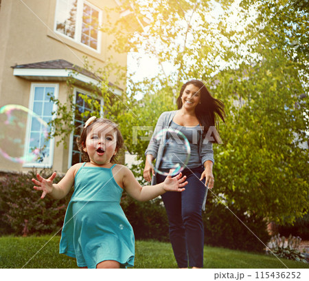 Running, toddler and mother outdoor in backyard for play, fun and adventure on summer weekend. Young kid, happy and woman chasing bubbles for explore environment, growth and development at home Running, toddler and mother outdoor in backyard for play, fun and adventure on summer weekend. Young kid, happy and woman chasing bubbles for explore environment, growth and development at home 115436252