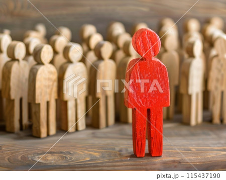 Red wooden figure stands out among crowd of wooden figures, symbolizing individuality, leadership 115437190