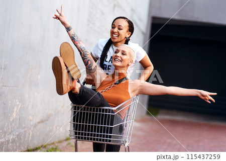 Friends, happy and shopping cart in outdoor for play, funny and bonding together in city for freedom. Women, town and adventure in trolley for comedy, laughing and crazy happiness in urban on weekend Friends, happy and shopping cart in outdoor for play, funny and bonding together in city for freedom. Women, town and adventure in trolley for comedy, laughing and crazy happiness in urban on weekend 115437259