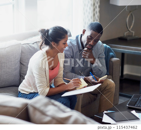 Couple, notebook and writing on sofa in morning with notes, payments and rent with tax in living room. Technology, tablet and sunlight with people on couch, cover and debt with finance for mortgage. Couple, notebook and writing on sofa in morning with notes, payments and rent with tax in living room. Technology, tablet and sunlight with people on couch, cover and debt with finance for mortgage. 115437462
