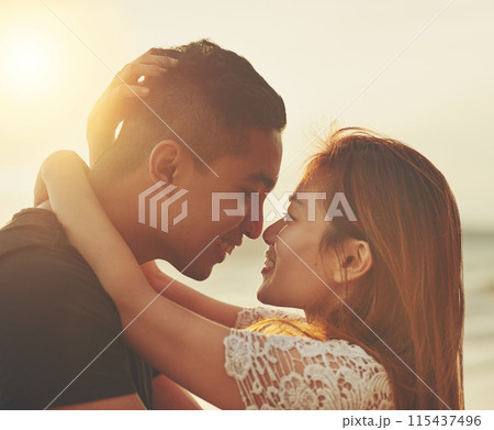 Love, couple and sunset on beach for care, support and together in nature with sunshine. Happiness, woman and man kiss outdoor for travel, adventure and holiday to Thailand for vacation in summer 115437496