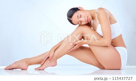 Legs, relax and Asian woman in studio for hair removal, cleaning and skin care for waxing. Underwear, model girl and pride for dermatology, laser treatment and cosmetics by white background with glow 115437727
