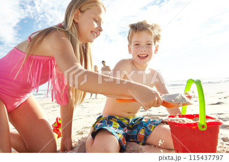 Children, beach and bucket by ocean for sand castle, fun and bonding together in nature. Siblings, happy and family in sunshine for development, holiday and creative on seashore in summer vacation 115437797