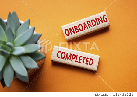 Onboarding Completed symbol. Concept word Onboarding Completed on wooden blocks. Beautiful orange background with succulent plant. Business and Onboarding Completed concept. Copy space 115438523