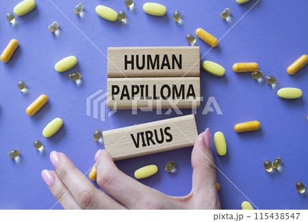 Human Papilloma Virus symbol. Concept word Human Papilloma Virus on wooden blocks. Doctor hand. Beautiful pink background with pills. Medicine and Human Papilloma Virus concept. Copy space 115438547