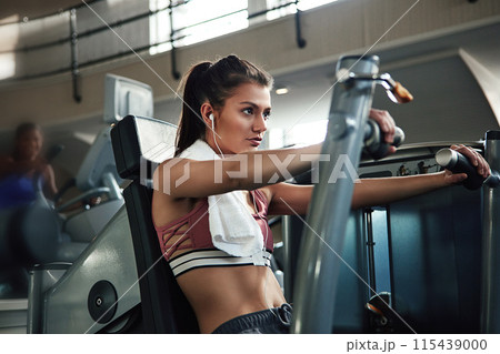 Girl, workout and chest press in gym for fitness, power and muscle development with earphones or towel. Music, machine and exercise in sports club for wellness, health and training with commitment Girl, workout and chest press in gym for fitness, power and muscle development with earphones or towel. Music, machine and exercise in sports club for wellness, health and training with commitment 115439000