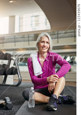 Gym, floor and portrait of mature happy woman with smile, relax and dumbbells with water bottle at workout. Exercise, training and confident female athlete on break for fitness, health and wellness 115439076