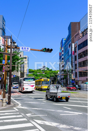 青空を背景に映える熊本城と繁華街を運行する路面電車・道路交通風景　(熊本市通町筋) 115439087
