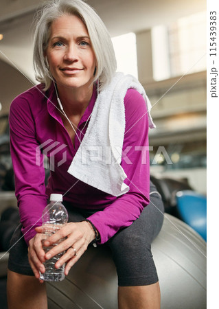 Relax, portrait of mature happy woman with gym ball, fitness and pride with water bottle at workout. Exercise, training and confident female athlete on break with smile, health and wellness in club. 115439383