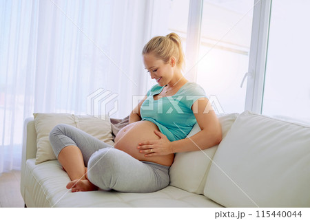 Pregnancy, smile and woman on sofa in home holding belly for maternity care with happiness. Love, relaxing and maternal female person from Australia touch stomach in living room at apartment. 115440044