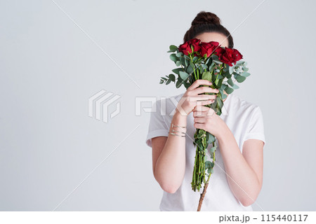 Bouquet, woman hide face and flowers for love with anniversary present, natural and sustainable product in studio. Female person, romantic rose and leaves for floral gift and date by white background 115440117