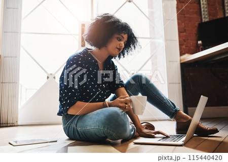 Woman, coffee and laptop on floor for remote work from home office in morning, scroll and thinking for freelance job. Person, writer and happy to relax with tea cup, drink and computer in apartment 115440420
