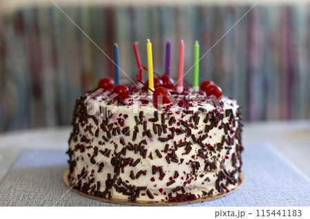 Black Forest cake with cherries, chocolate chips and whipped cream. Birthday cake with candles. Shvartsvald cherry cake, a traditional German pastry. Selective focus, close-up. 115441183