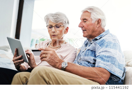Senior couple, home and tablet with bank card on sofa for online shopping, payment and retirement plan. People, serious and couch at living room for internet banking, budget and investment or finance Senior couple, home and tablet with bank card on sofa for online shopping, payment and retirement plan. People, serious and couch at living room for internet banking, budget and investment or finance 115441192