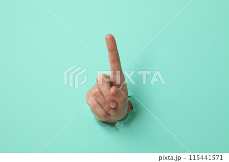 Female hand showing index finger on blue background 115441571