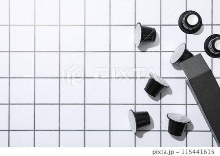 Black coffee capsules and box on light background, space for text Black coffee capsules and box on light background, space for text 115441615