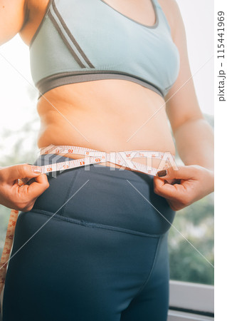 fat woman, fat belly, chubby, obese woman hand holding excessive belly fat with measure tape, woman diet lifestyle concept fat woman, fat belly, chubby, obese woman hand holding excessive belly fat with measure tape, woman diet lifestyle concept 115441969