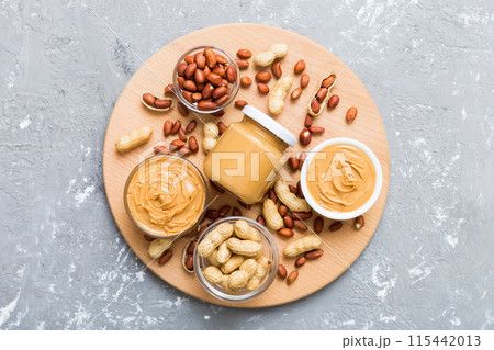 Bowl of peanut butter and peanuts on table background. top view with copy space. Creamy peanut pasta in small bowl Bowl of peanut butter and peanuts on table background. top view with copy space. Creamy peanut pasta in small bowl 115442013