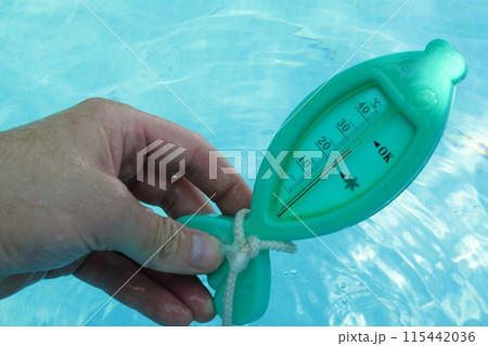 a man hand checks the temperature with a thermometer on a sunny day a man hand checks the temperature with a thermometer on a sunny day 115442036