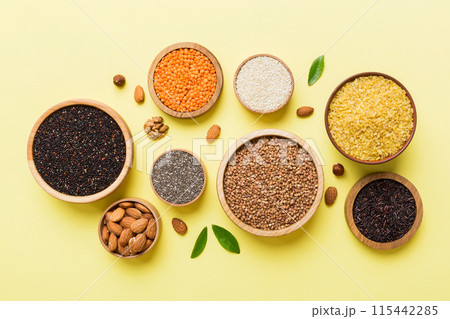 Various superfoods in smal bowl on colored background. Superfood as rice, chia, quinoa, lentils, nuts, sesame seeds, almonds. top view copy space 115442285