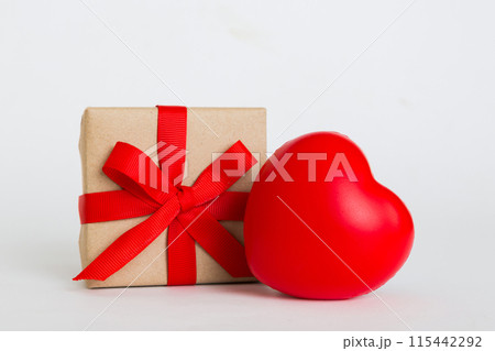 gift box with red bow and red heart on colored background. Perspective view. Flat lay 115442292
