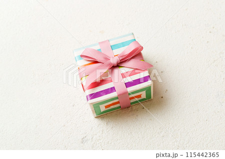 wrapped Christmas or other holiday handmade gift box in color paper with ribbon on colored background. Present box, decoration of gift on colored table, top view with copy space wrapped Christmas or other holiday handmade gift box in color paper with ribbon on colored background. Present box, decoration of gift on colored table, top view with copy space 115442365