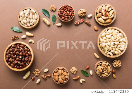 mixed nuts in wooden bowl. Mix of various nuts on colored background. pistachios, cashews, walnuts, hazelnuts, peanuts and brazil nuts mixed nuts in wooden bowl. Mix of various nuts on colored background. pistachios, cashews, walnuts, hazelnuts, peanuts and brazil nuts 115442389