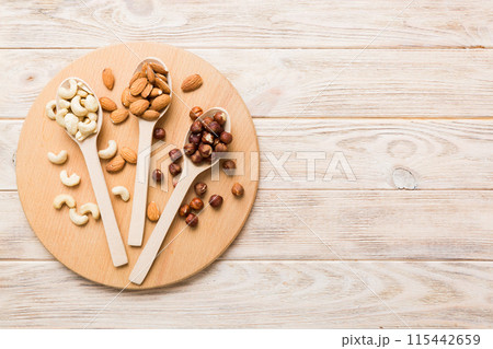 Assortment of nuts in wooden spoon on colored table. Cashew, hazelnuts, walnuts, almonds. Mix of nuts Top view with copy space Assortment of nuts in wooden spoon on colored table. Cashew, hazelnuts, walnuts, almonds. Mix of nuts Top view with copy space 115442659