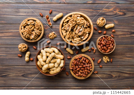 Walnut kernel halves, in a wooden bowl. Close-up, from above on colored background. Healthy eating Walnut concept. Super foods with copy space 115442665