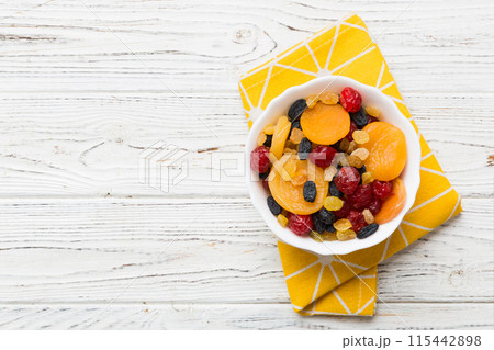 Bowl with different dried fruits on table background, top view. Healthy lifestyle with copy space 115442898