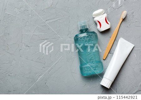 Mouthwash and other oral hygiene products on colored table top view with copy space. Flat lay. Dental hygiene. Oral care products and space for text on light background. concept Mouthwash and other oral hygiene products on colored table top view with copy space. Flat lay. Dental hygiene. Oral care products and space for text on light background. concept 115442921