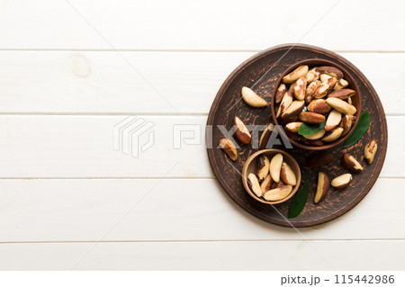Fresh healthy Brazil nuts in bowl on colored table background. Top view Healthy eating bertholletia concept. Super foods Fresh healthy Brazil nuts in bowl on colored table background. Top view Healthy eating bertholletia concept. Super foods 115442986