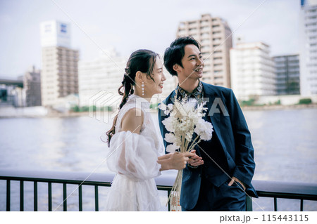 海辺で花束を持つ新郎新婦 115443115