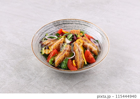 Crunchy thai style chicken salad in bowl over light stone background. Close up view Crunchy thai style chicken salad in bowl over light stone background. Close up view 115444940