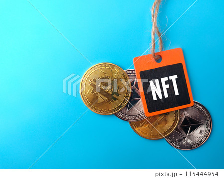 Top view golden bitcoin,silver ethereum and wooden tag with word NFT on blue background. 115444954