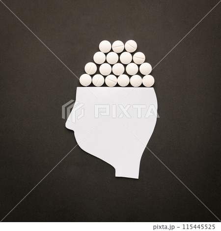 Drugs addiction and mental withdrawal symptoms concept. Human head with white pills on black background. International Day against Drug Abuse. 115445525