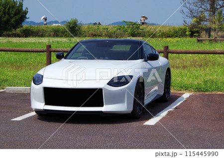 快晴の休日に白色の国産スポーツカーでドライブに出掛けて公園の駐車場で休憩して景色を眺めているイメージ 快晴の休日に白色の国産スポーツカーでドライブに出掛けて公園の駐車場で休憩して景色を眺めているイメージ 115445990