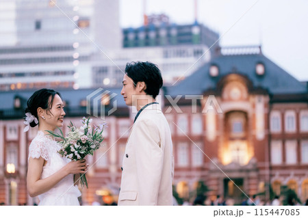 東京駅前撮り向かい合っている新郎新婦 東京駅前撮り向かい合っている新郎新婦 115447085