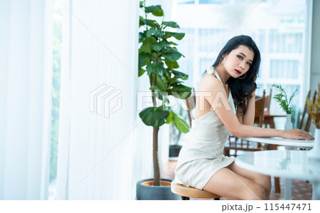 Portrait beautiful asian freelance Success people business woman fashion model in summer white sleeveless dress and coffee in cup in coffee shop. 115447471